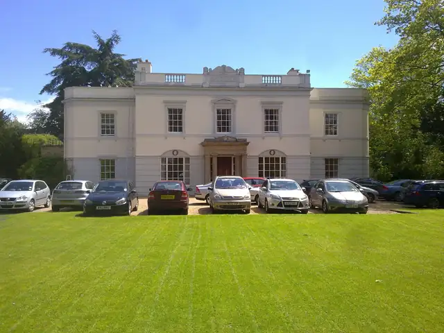Large cream-painted country house exterior with sash windows