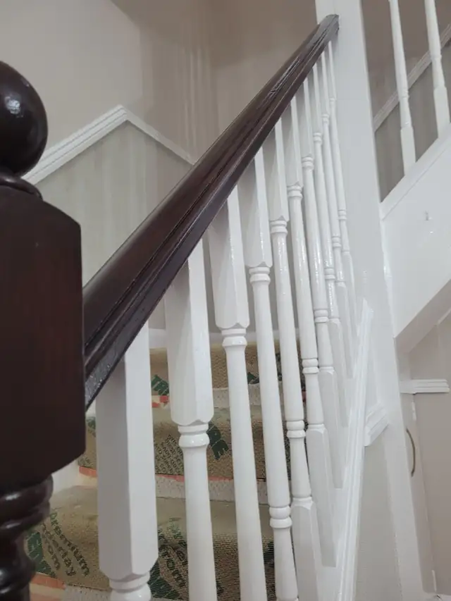 Freshly painted white spindles and stair rail on a hall, stairs and landing in Hinckley