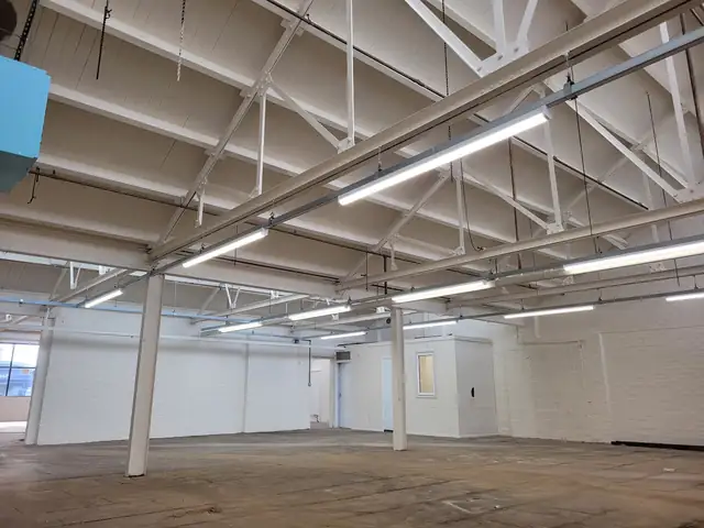 Commercial unit interior with freshly painted white roof beams and walls