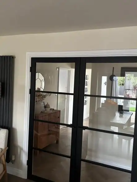 Cream hallway with black-framed glass internal doors, decorated by Nick Hebden