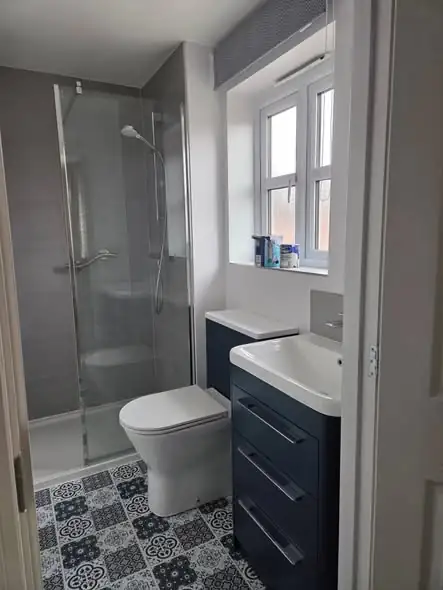 New en-suite in Desford with grey walls and patterned floor tiles, decorated
