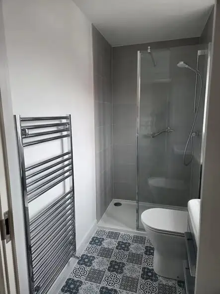 New en-suite in Desford with grey walls, towel rail and walk-in shower
